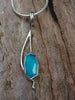 Sterling silver long drop pendant with sky blue agate rose cut oblong flower and silver snake chain. sitting on a mossy log in the sunshine